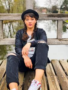 Singer-Song-Writerin Leona Heine sitzt auf einem Bootssteg